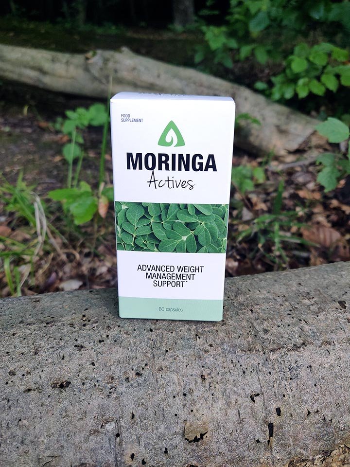 caja con blanca y verde con letras negras dentro de cuenco con capsulas de suplemento