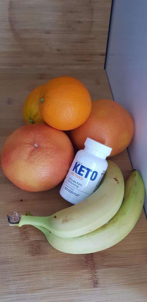 envase de color blanco con letras azules junto a plátanos y naranjas.