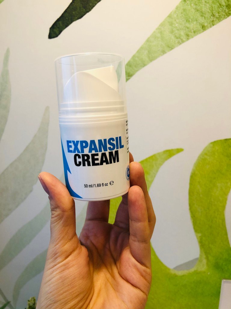 Caja de bote crema, de color blanco con 2 flechas una azul otra negra, letras negras y azules.