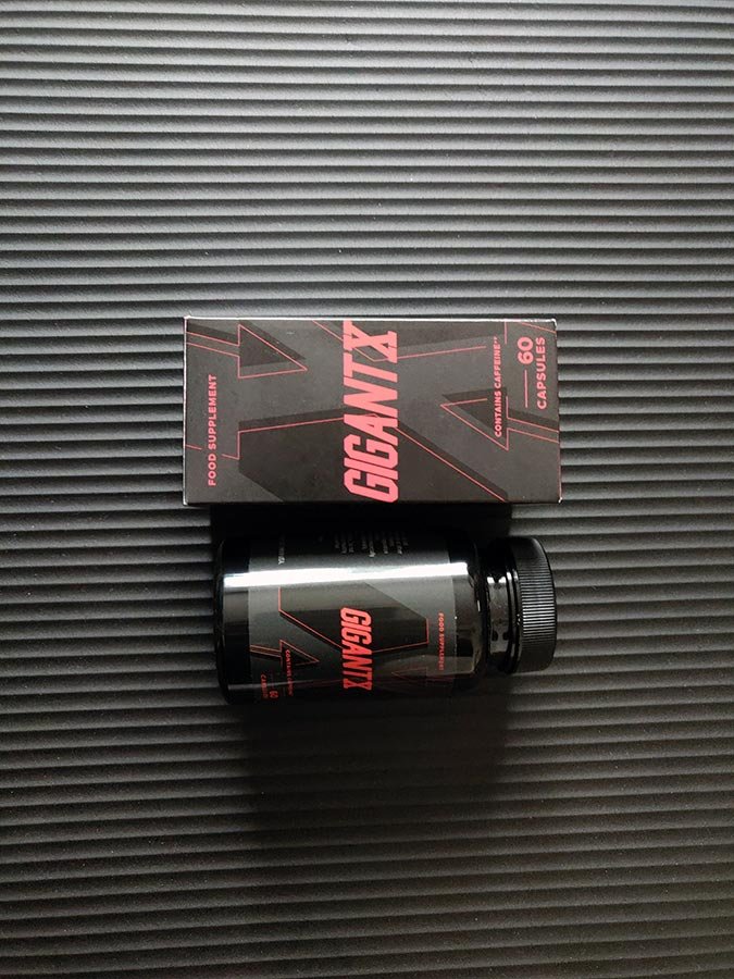 caja y bote de suplemento negra con letras rojas.