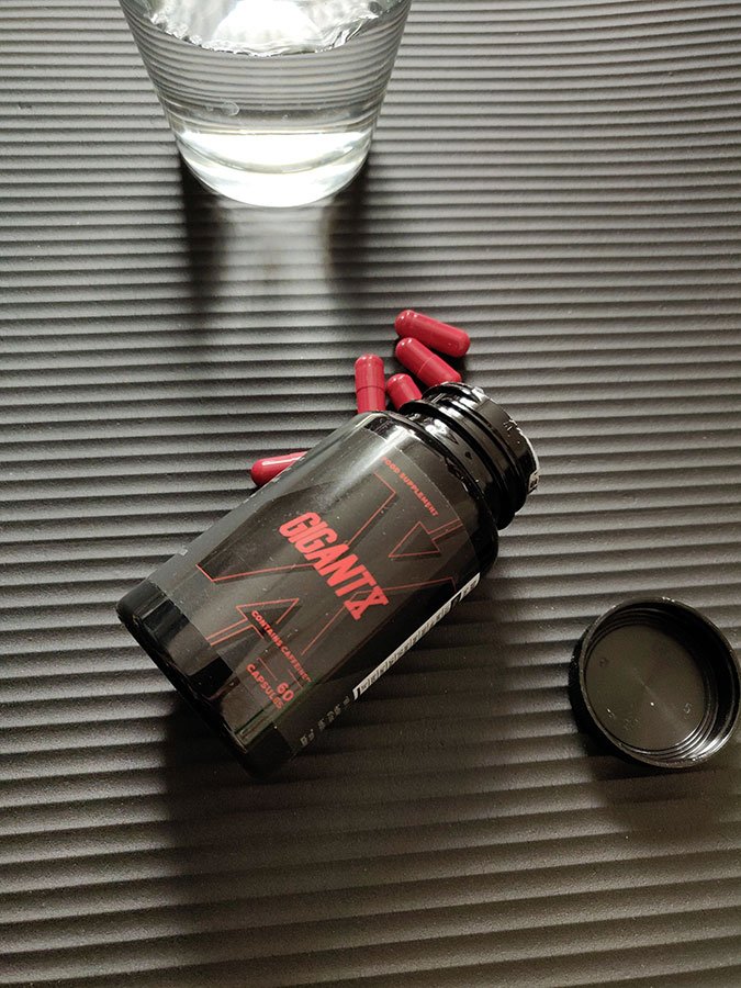 Bote de suplemento negra con letras rojas.