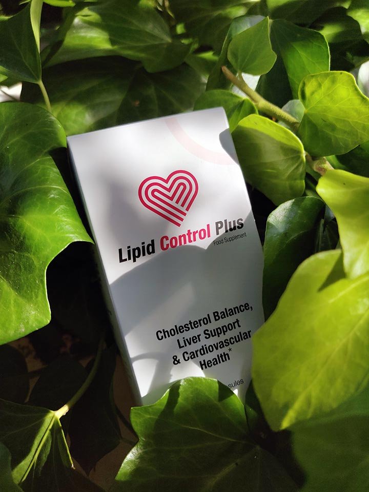 caja blanca con letras negras y rojas, corazón rojo, entre plantas