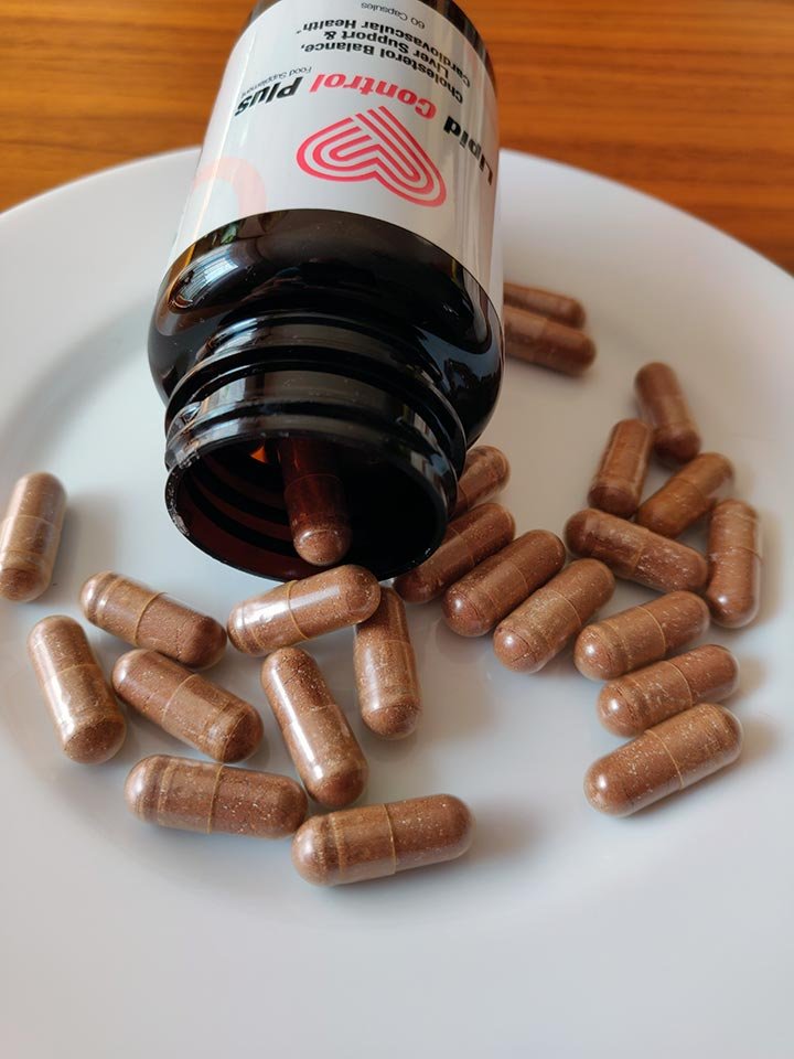 cápsulas y bote de suplemento encima de plato