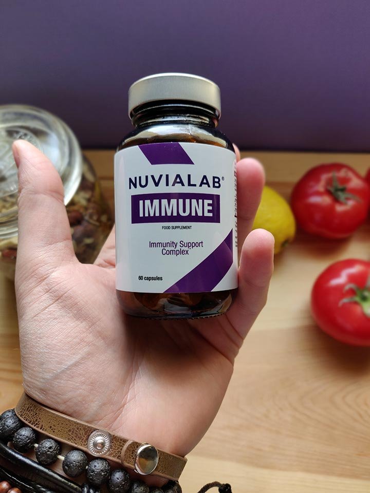 mano sosteniendo un bote de suplemento