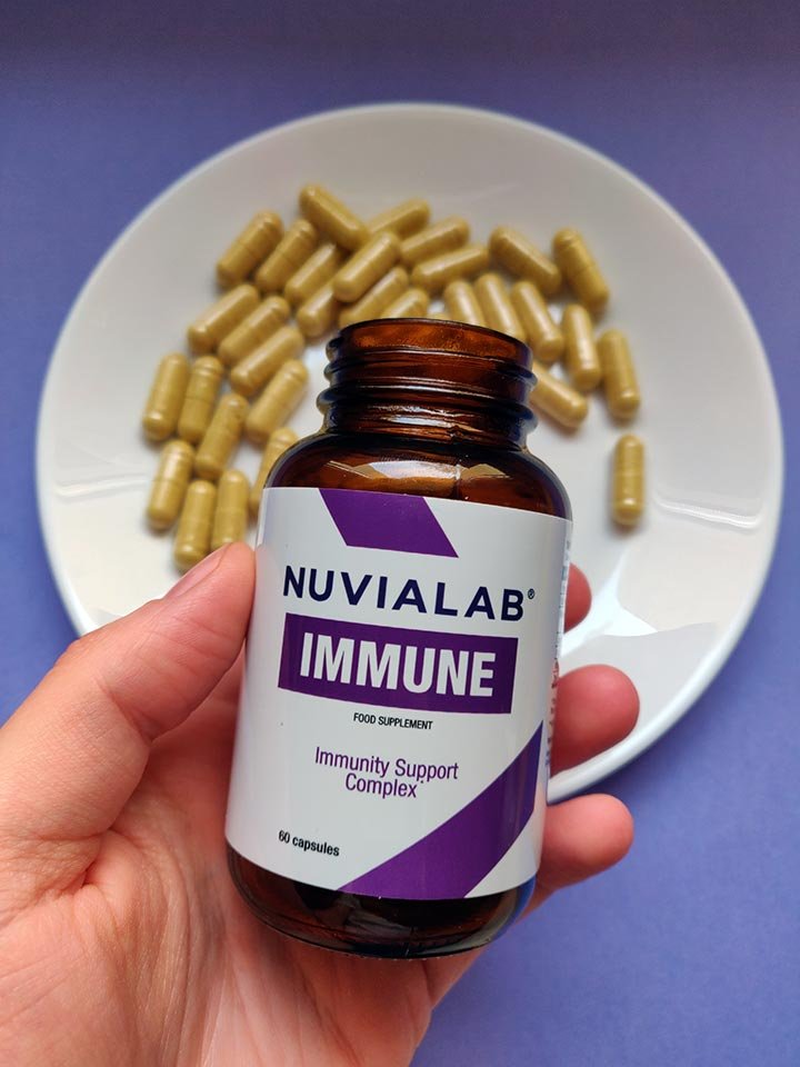 mano sosteniendo un bote de suplemento