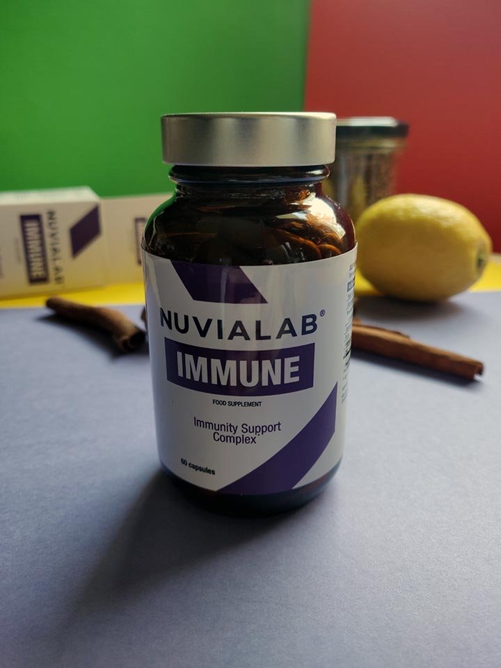 Bote de suplemento encima de una mesa junto a un limón