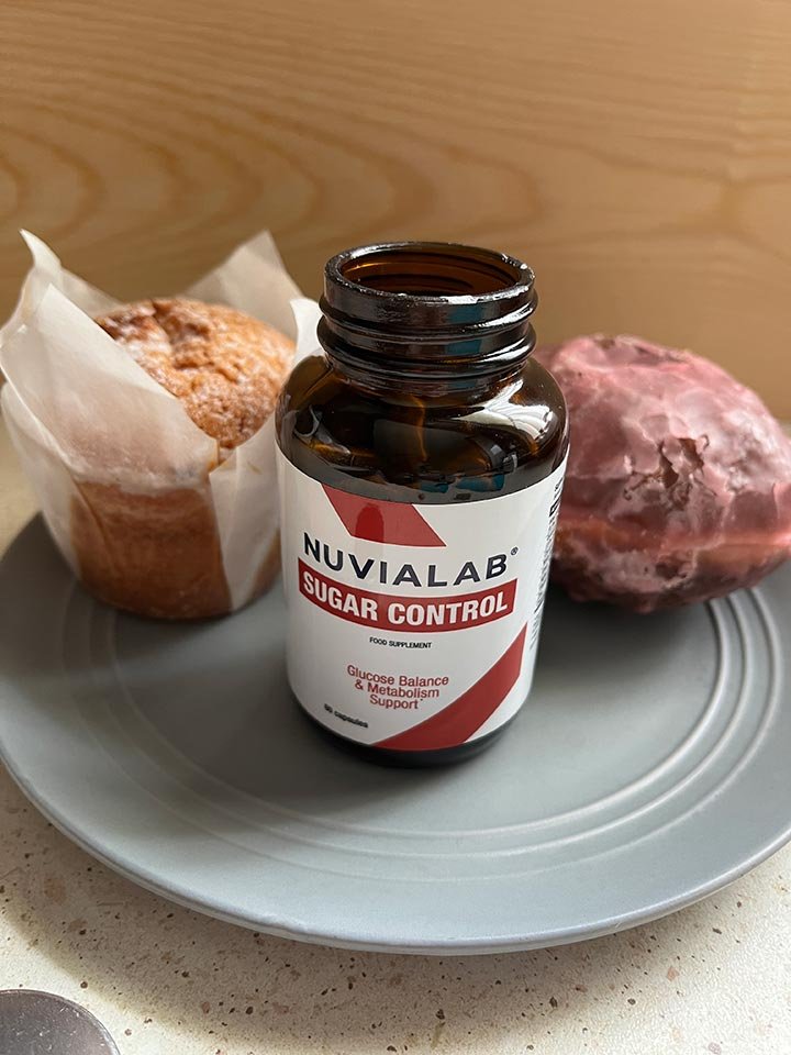 bote de suplemento encima de un plato con cup cake